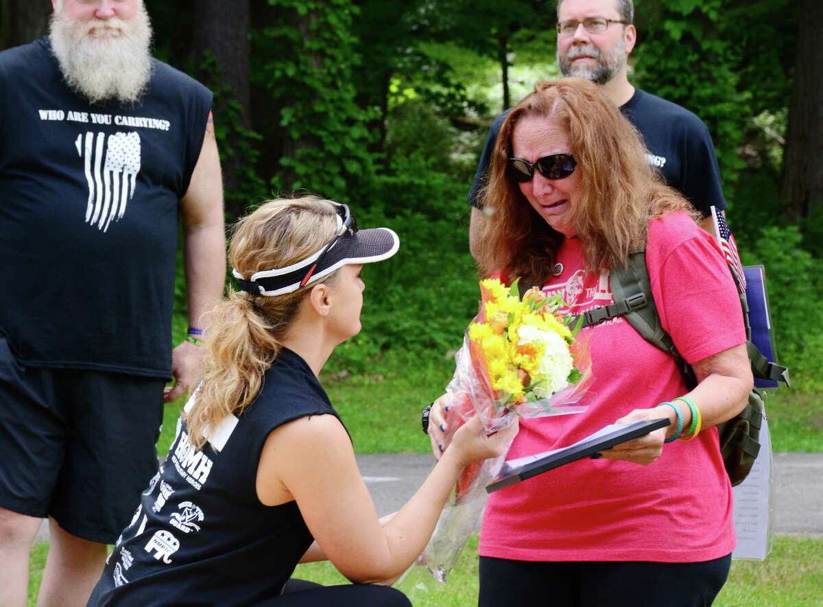 Harrybrooke Park in New Milford honored fallen military heroes at the "Who Are You Carrying" event on Sunday, May 28, 2017. The event recognized Petty Officer First Class Jason D. Lewis, from Brookfield. Valerie Lewis, Asst. Executive Director of the park, offers a bouguet of flowers to Lewis' mom, Jean Mariano of New Milford.