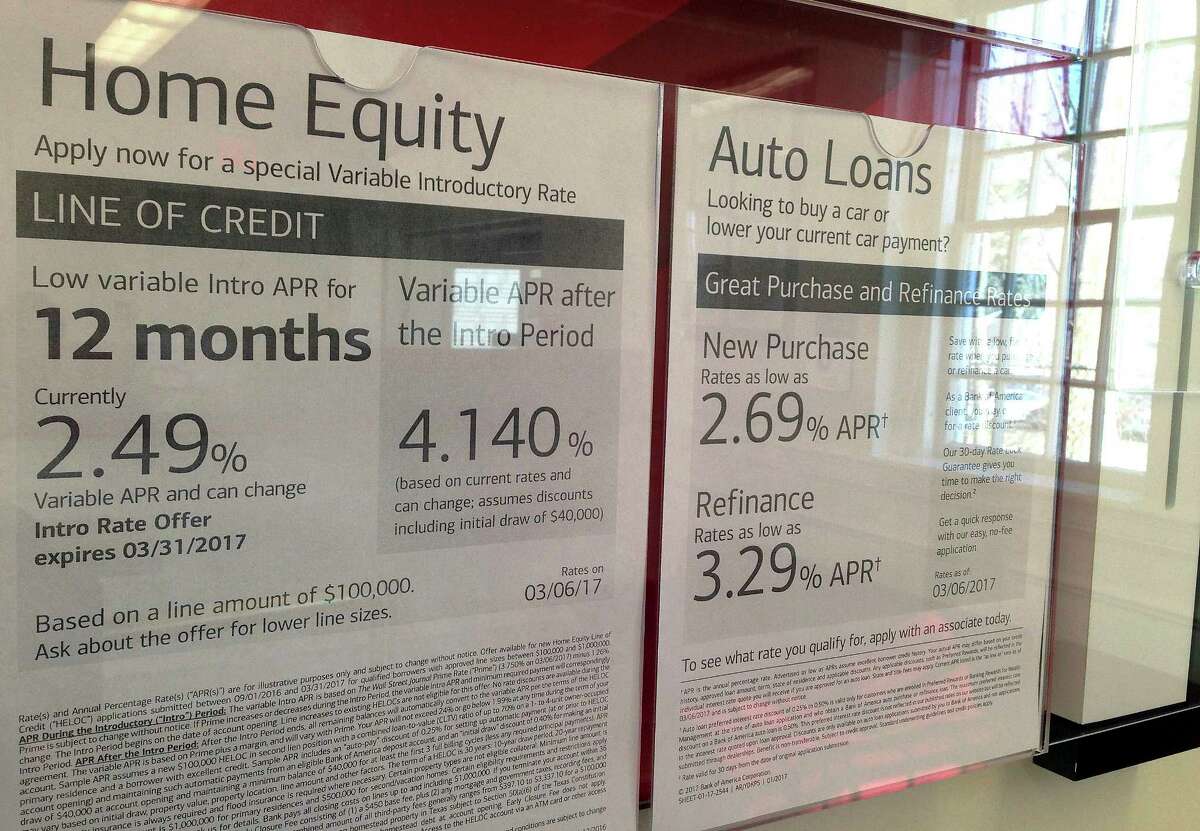 FILE - In this March 6, 2017, file photo, home equity loan rates are among the loan rates displayed at a bank in North Andover, Mass. U.S. housing equity now equals 58 percent of home values, the highest such point since 2006. Yet borrowing against that equity has barely budged from post-recession lows, which helps explain why consumer spending remains weak eight years after the Great Recession ended. (AP Photo/Elise Amendola, File)