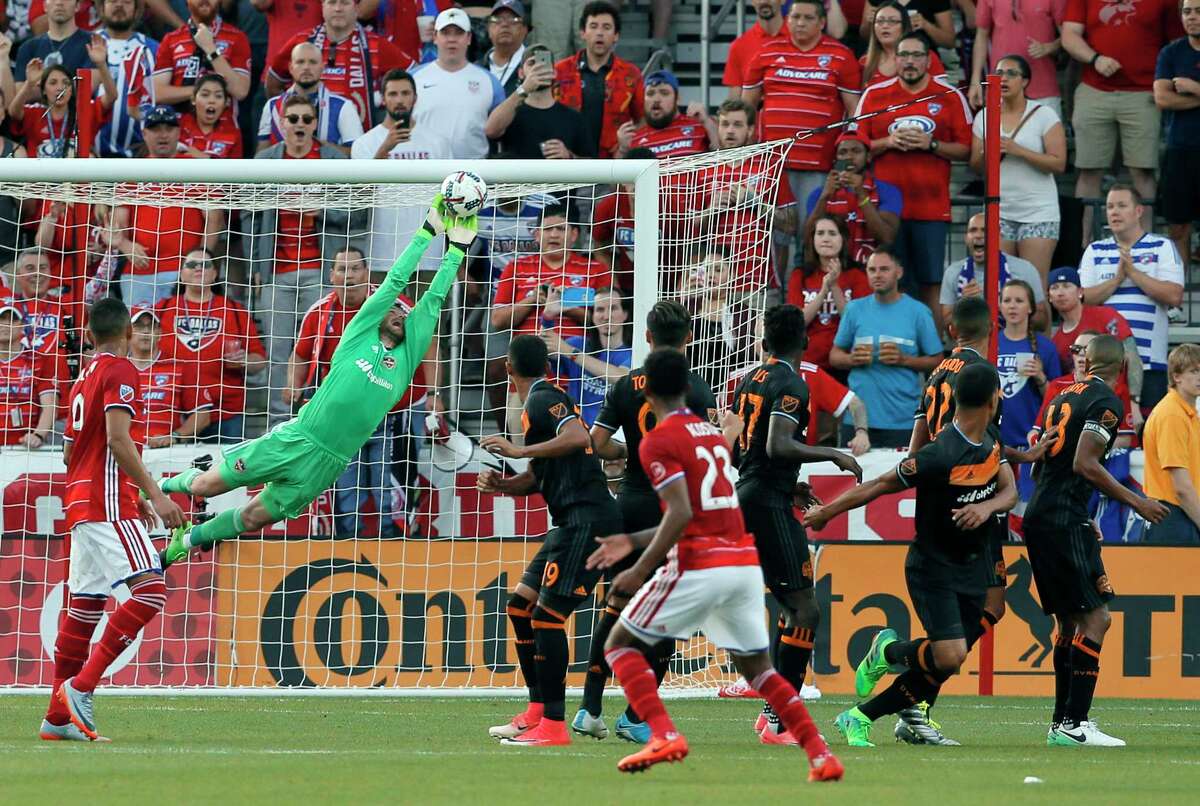 Dynamo goalkeeper Tyler Deric stretches out to make a save on a free kick by FC Dallas in the first half Sunday night in Frisco.