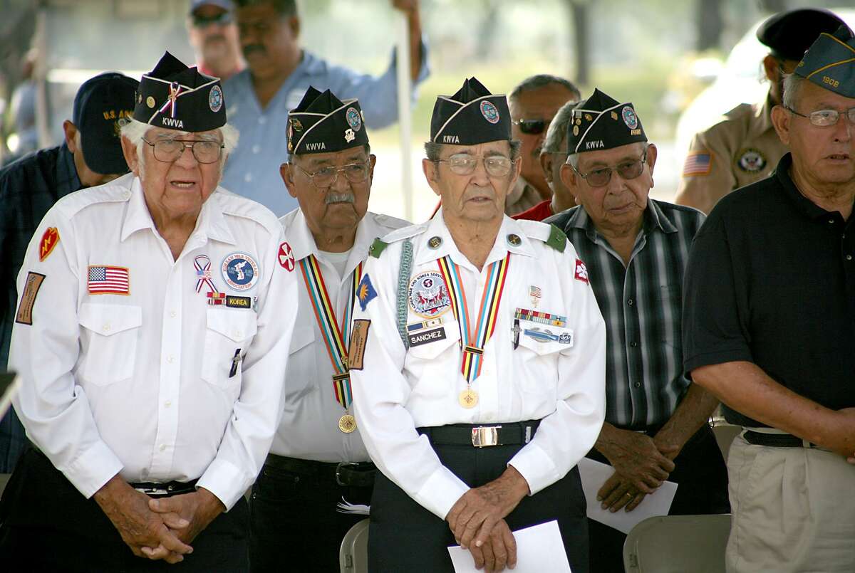 Veterans rise in prayer during a ceremony in commemoration of fallen soldiers led by Bishop James Tamayo at the Calvary Catholic Cementery on Saturday morning.
