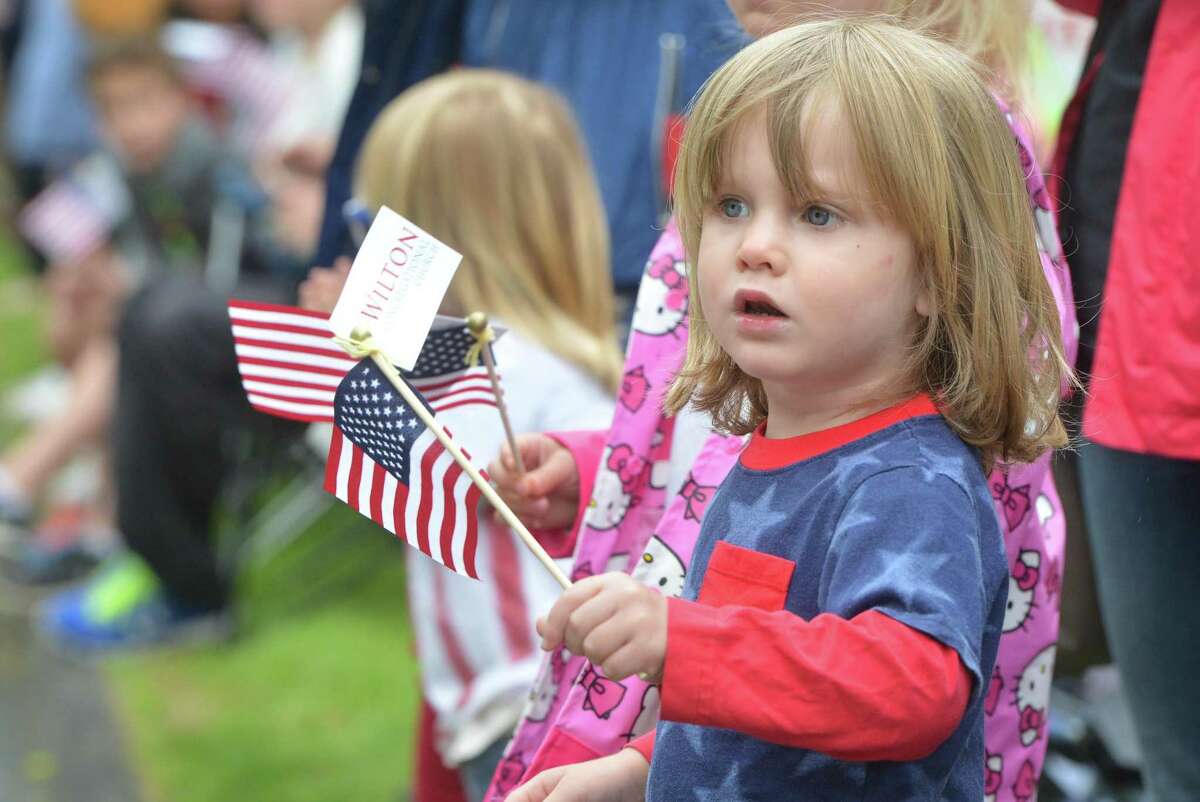 Jax Lewis waves the flag as marchers approach during the Wilton Memorial Day Parade on Monday.