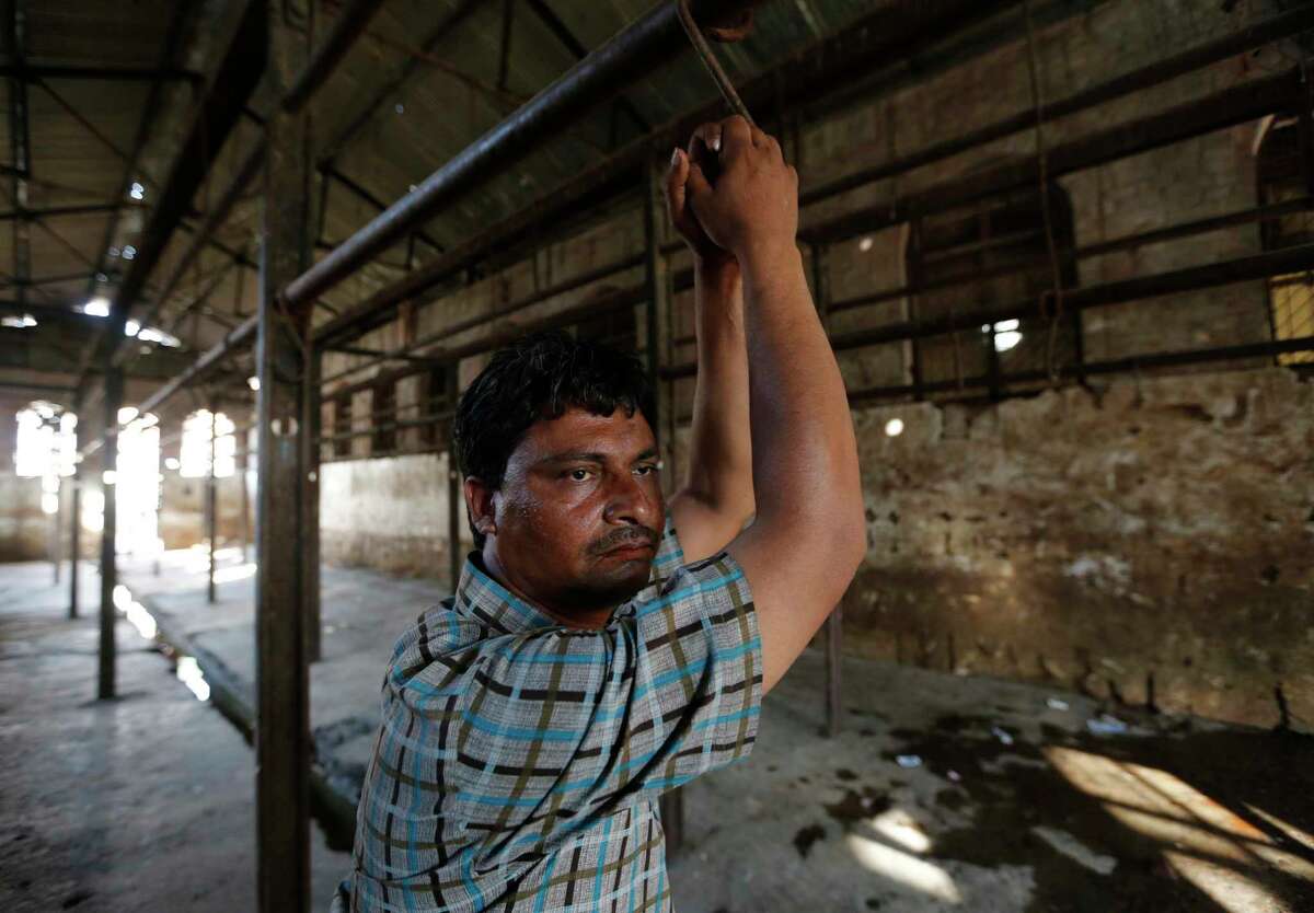 FILE - In this Sunday, March 26, 2017, file photo, Mehta, 40, stands at a slaughter house where he used to work after it was shutdown by authorities in Allahabad, India. The Indian government has banned the sale of cows and buffaloes for slaughter in a move to protect animals considered holy by many Hindus. State governments and industry bodies have criticized the ban as a blow to beef and leather exports that will also leave hundreds of thousands jobless and deprive millions of Christians, Muslims and poor Hindus of a cheap source of protein. (AP Photo/Rajesh Kumar Singh, file)