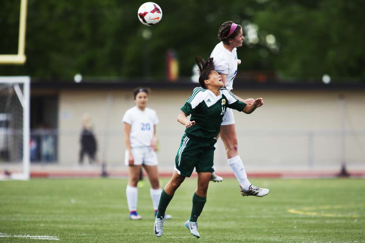 Midland's Carlee Davis and Dow's Annie Meilink attempt a header in a game at Midland High School on Tuesday.
