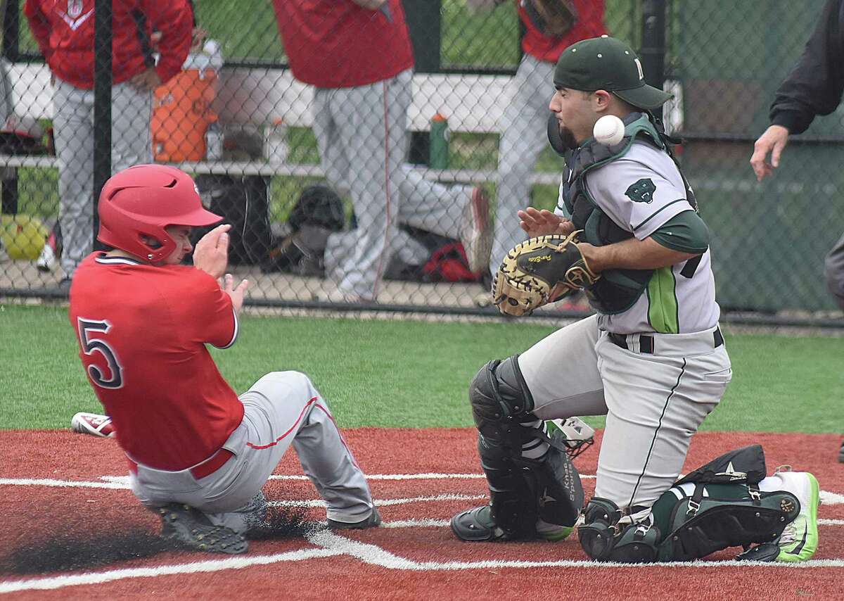 Norwalk catcher Marco Monteiro, right, can't come up with the ball on a play at the plate as Conard's Maxwell Main scores during the Chieftains' 8-4 win over the hosts Bears in the first round of the CIAC Class LL baseball tournament.