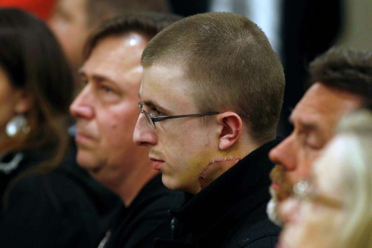 Micah Fletcher, a victim of a stabbing attack on a light rail train that left two dead, watches as suspect Jeremy Christian is arraigned in Multnomah County Circuit Court in Portland, Ore., Tuesday, May 30, 2017. Authorities say Christian started verbally abusing two young women, including one wearing a hijab on the train Friday, when three men on the train intervened, police say. (Beth Nakamura/The Oregonian via AP, Pool)
