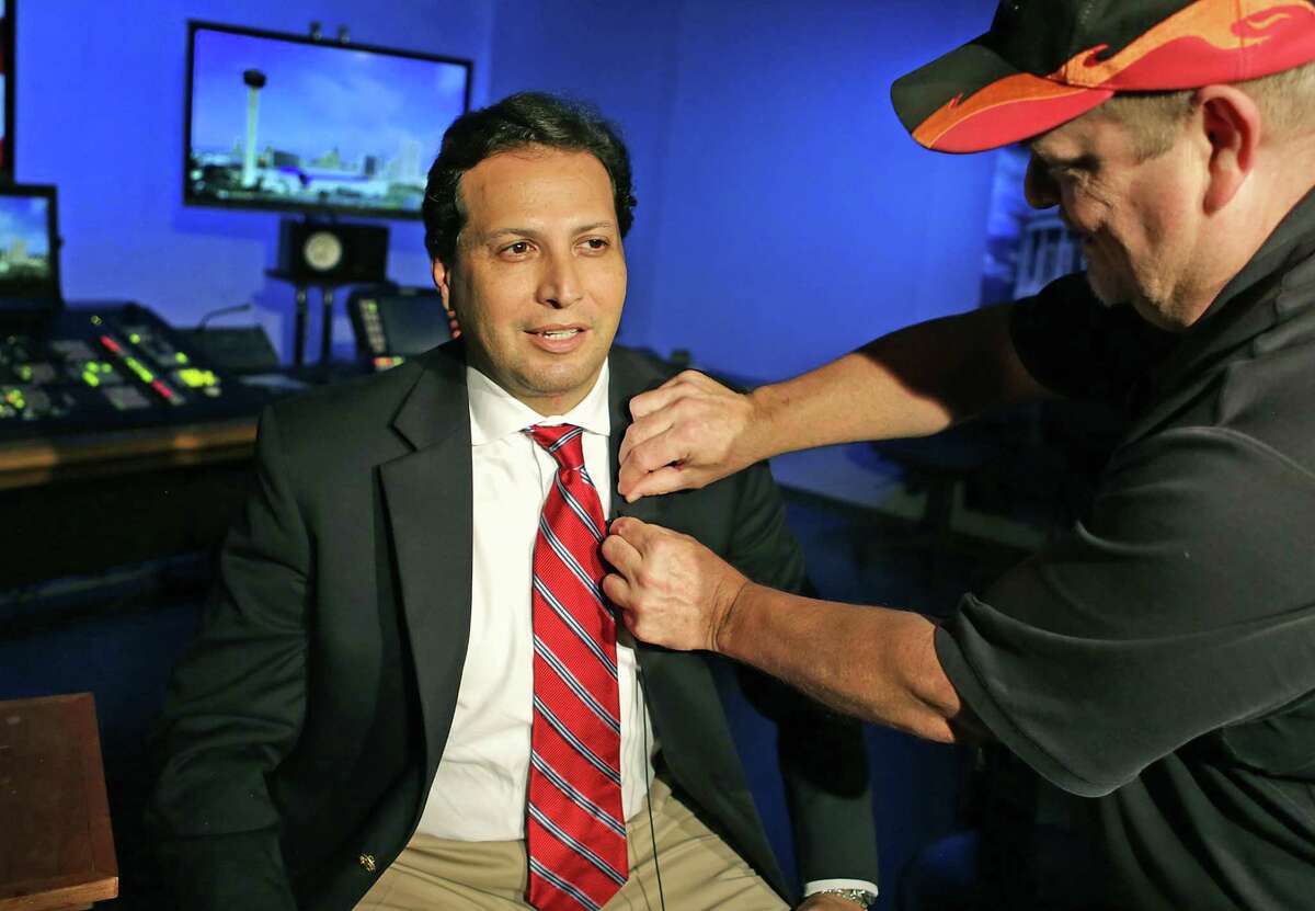 State Rep. Poncho Nevárez, D-Eagle Pass, left, has a microphone placed on him by Randy Allee, as he prepares to be interviewed by CNN from the KLRN Studios on May 30. Nevárez and fellow Democratic legislators on Wednesday called for a ban on open carrying of long guns, including rifles and shotguns, in the wake of the Sunday massacre in Sutherland Springs.