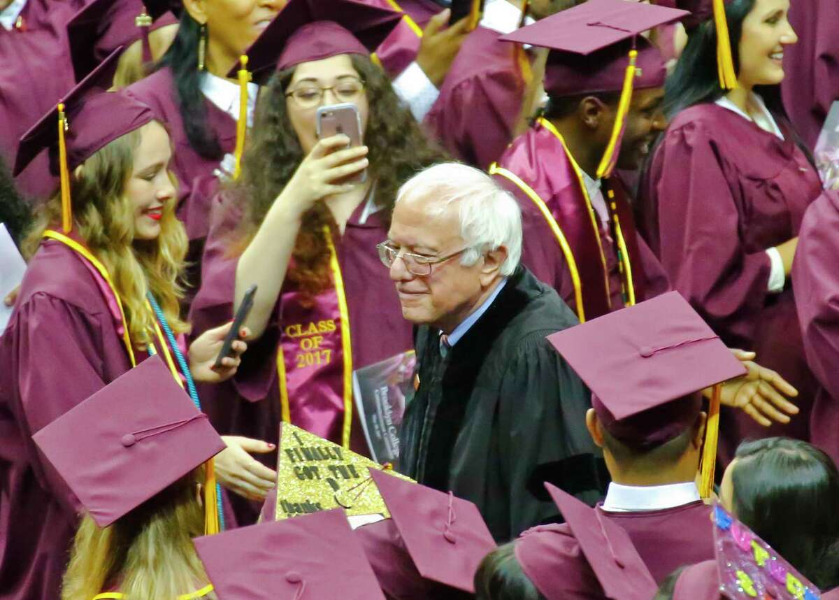 Vermont Sen. Bernie Sanders walks between graduates as he arrives for the Brooklyn College commencement ceremony, Tuesday, May 30, 2017, in New York. The former Democratic presidential candidate, who hails from Brooklyn and attended the school for a year, urged graduates to stand together and not let demagogues divide the country. (AP Photo/Bebeto Matthews) ORG XMIT: NYBM102