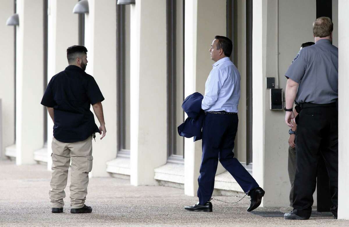State Sen. Carlos Uresti is escorted to the San Antonio federal courthouse on May 17 following his arrest in two criminal cases. He is facing 13 different charges between the two cases, including bribery, wire fraud and conspiracy. He entered a pleas of not guilty in both cases on Tuesday.