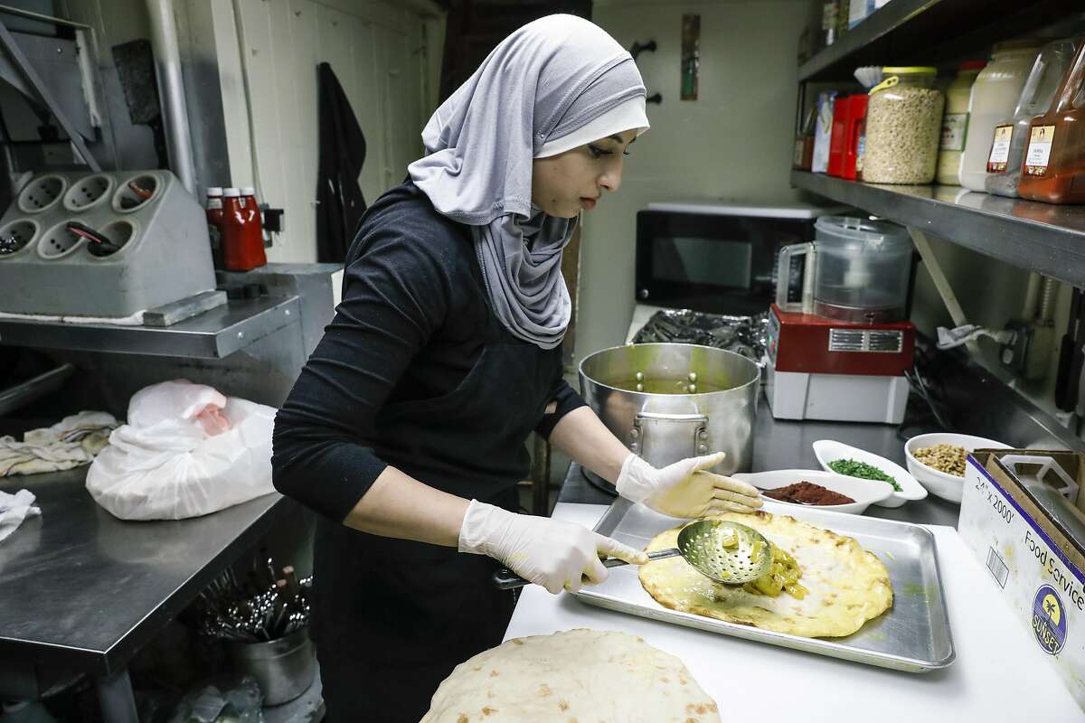 Chef Tahani Mohammad tops Arabic bread with an onion mixture for Mousakhan at Old Jerusalem Restaurant on Tuesday, May 23, 2017 in San Francisco, Calif.