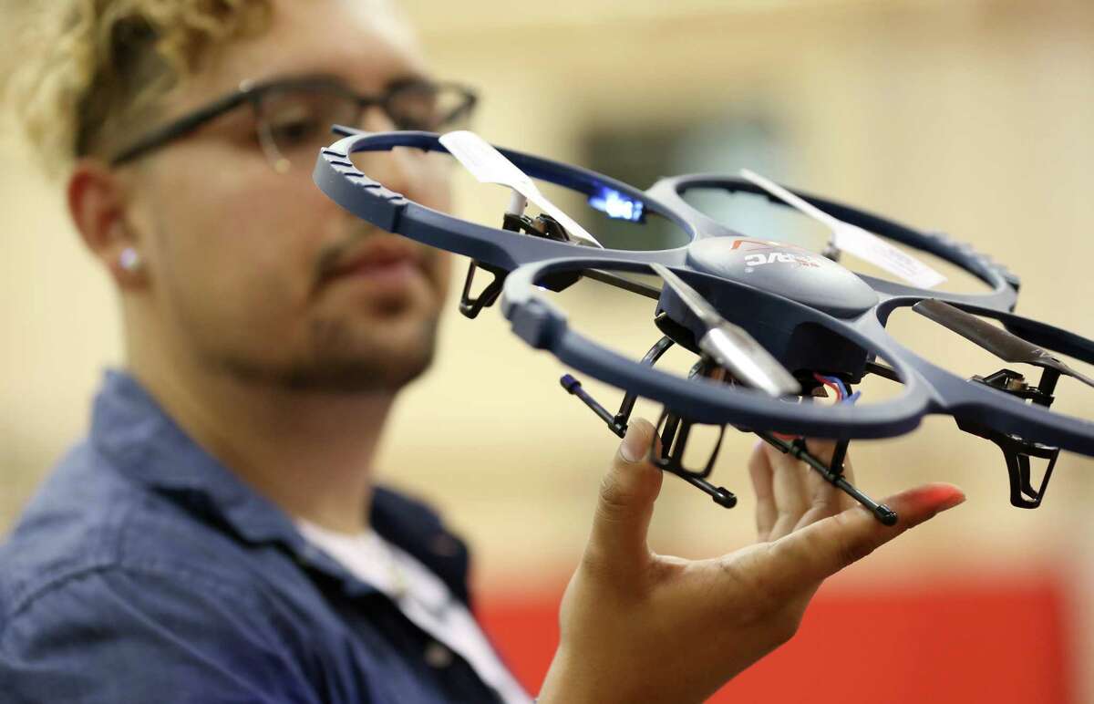 Jose Luis Del Aguila examines a drone. "Flying an unmanned aircraft has a lot of rules," he says.