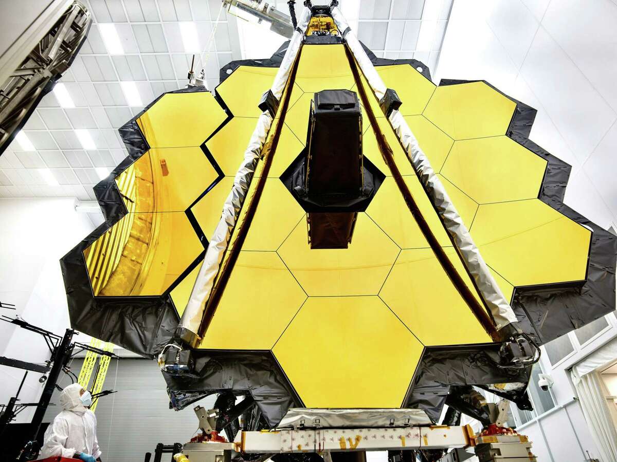 This NASA photo released on May 16, 2017 shows the primary mirror of NASAs James Webb Space Telescope inside a cleanroom at NASAs Johnson Space Center in Houston,Texas where it will undergo its last cryogenic test before it is launched into space in 2018. In preparation for testing, the wings of the mirror (which consist of the three segments on each side) were spread open. This photo shows one fully deployed wing, and one that is moments from being fully deployed. An engineer observes the move.The James Webb Space Telescope is the worlds most advanced space observatory. It is designed to unravel some of the greatest mysteries of the universe, from discovering the first stars and galaxies that formed after the big bang to studying the atmospheres of planets around other stars. / AFP PHOTO / NASA / Chris GUNN / RESTRICTED TO EDITORIAL USE - MANDATORY CREDIT "AFP PHOTO / NASA/CHRIS GUNN" - NO MARKETING NO ADVERTISING CAMPAIGNS - DISTRIBUTED AS A SERVICE TO CLIENTS CHRIS GUNN/AFP/Getty Images