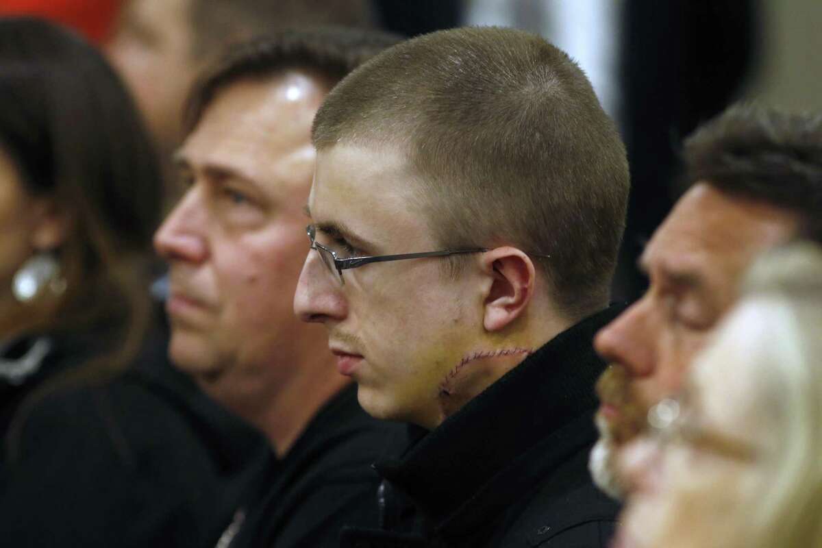 Micah Fletcher, a victim of a stabbing attack on a light rail train that left two dead, watches as suspect Jeremy Christian is arraigned in Multnomah County Circuit Court in Portland, Ore., Tuesday, May 30, 2017. Authorities say Christian started verbally abusing two young women, including one wearing a hijab on the train Friday, when three men on the train intervened. (Beth Nakamura/The Oregonian via AP, Pool)