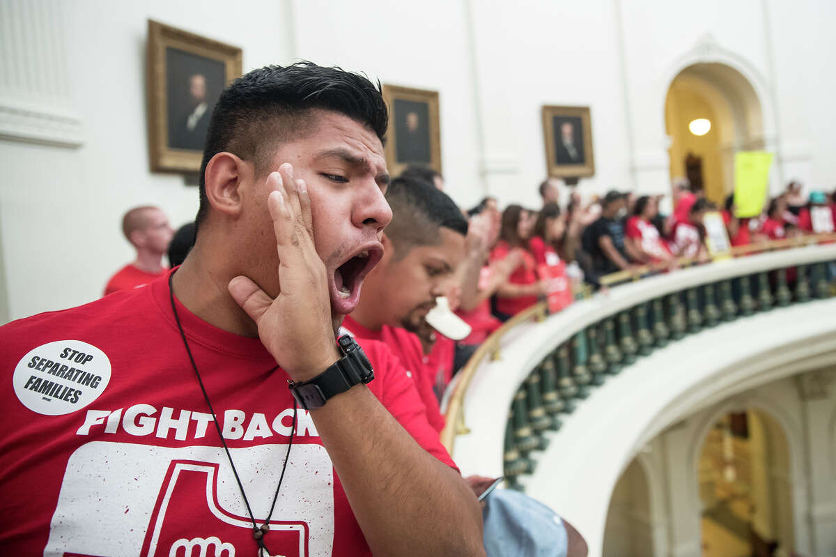 Pedro Paredes joins hundreds of protesters lining the balconies of the state Capitol rotunda ﻿on Monday, the last day of the legislative session, to protest Senate Bill 4, which compels local police to enforce U.S. immigration law. (Ricardo Brazziell/Austin American-Statesman via AP)