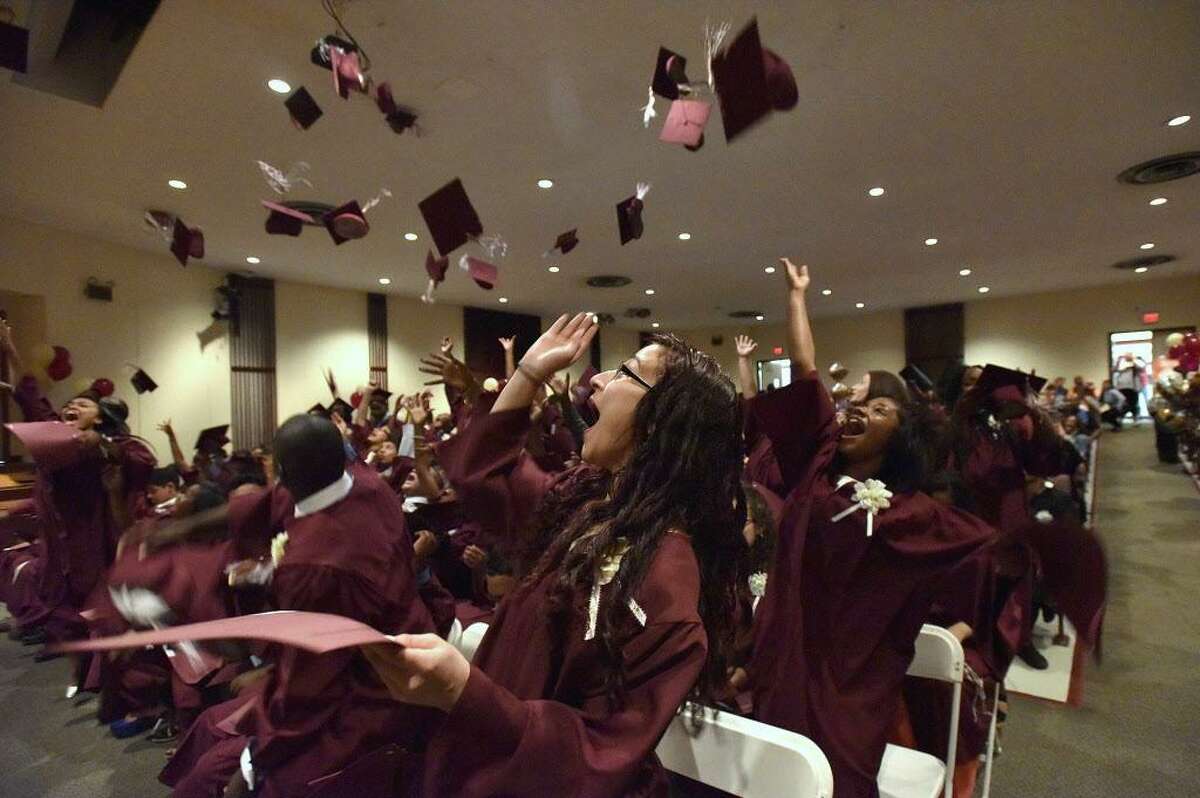 FILE — Savannah Adam, center, and other graduates toss their moartarboards into the air during the graduation ceremony for Trailblazers Academy in Stamford, Conn., on Friday, June 19, 2015.