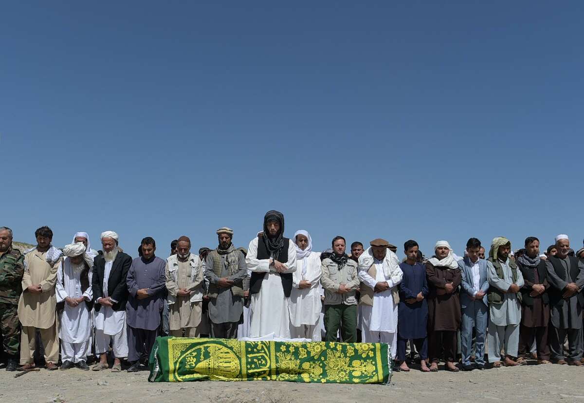 Afghan mourners and relatives pray in front of the coffin of one of the 80 victims killed at a cemetery in Kabul on June 1, 2017, a day after a massive truck bomb in the Afghan capital. At least 80 people were killed and hundreds wounded May 31 when a massive truck bomb ripped through Kabul's diplomatic quarter, bringing carnage to the streets of the Afghan capital and shattering windows hundreds of metres away. / AFP PHOTO / SHAH MARAISHAH MARAI/AFP/Getty Images