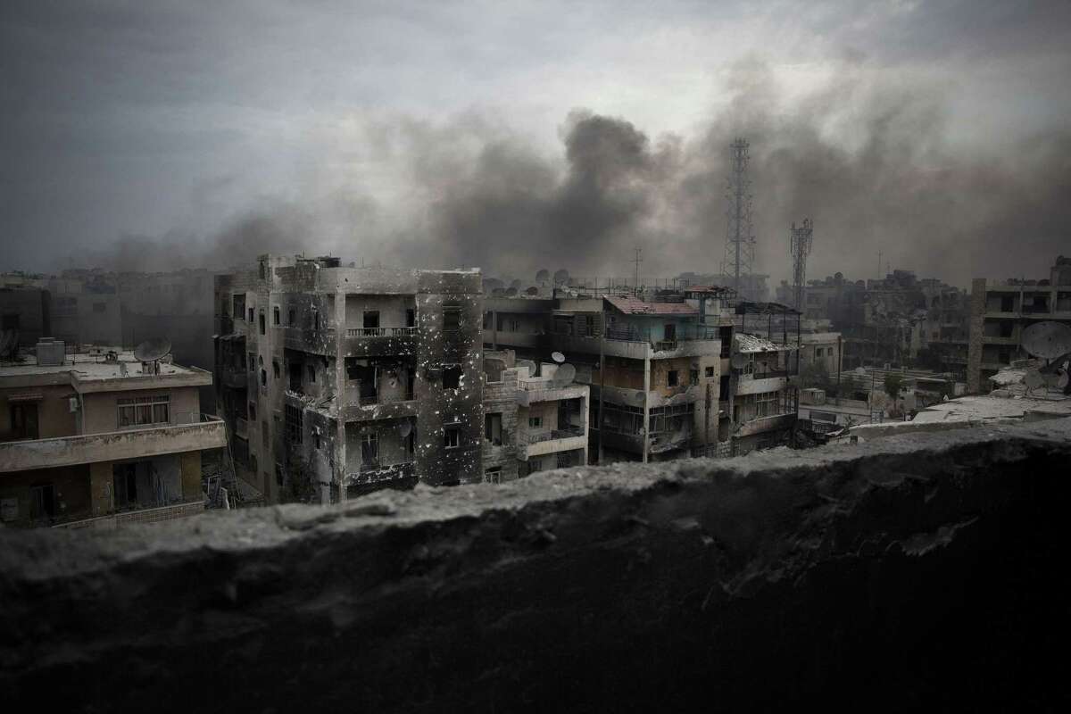 FILE - In this Oct. 2, 2012 file photo, smoke rises over Saif Al Dawla district, in Aleppo, Syria. Veteran Syrian rebels who have fought Assad for years are struggling to find a place in a bewildering battlefield where several wars are all being waged at once by international powers. Battered by defeats, they bounce from alliance to alliance, feeling abandoned by the U.S. and faced with choosing whether to ally with Turkey or al-Qaida. (AP Photo/ Manu Brabo, File)