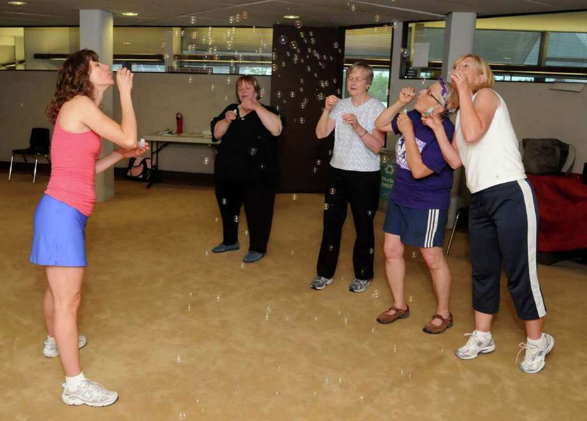 From left, Healthy Steps instructor Alison DiPinto of Brookfield, Kathryn Kosek of Danbury, Nancy Wolf of Danbury, Vickie Winkelman of Danbury, and Ruth Heringa of Wingdale, N.Y. workout together on Thursday May 27, 2010 at Ann's Place in Danbury starting with a fun warmup routine of blowing bubbles to open up their airways. The group of breast cancer survivors are instructed by DiPinto in the Lebed Method of movement.