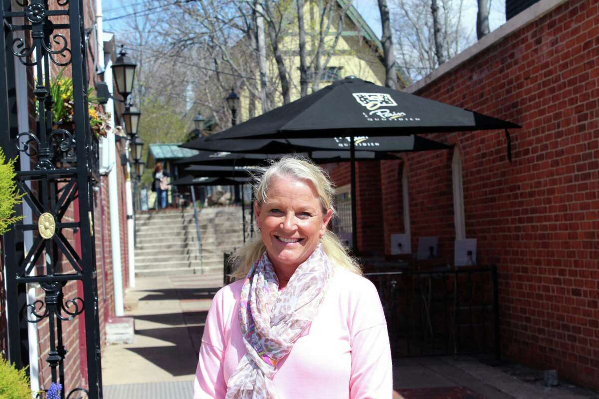Chamber of Commerce Executive Director Tucker Murphy stands outside her Elm Street office, the Outback-to-Elm pedestrian access point behind her.