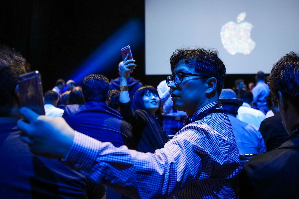 Osen Pilju Kang (C) takes a selfie with the Apple logo, ahead of a Apple's annual Worldwide Developers Conference presentation at the Bill Graham Civic Auditorium in San Francisco, California, onJune 13, 2016. / AFP PHOTO / GABRIELLE LURIEGABRIELLE LURIE/AFP/Getty Images
