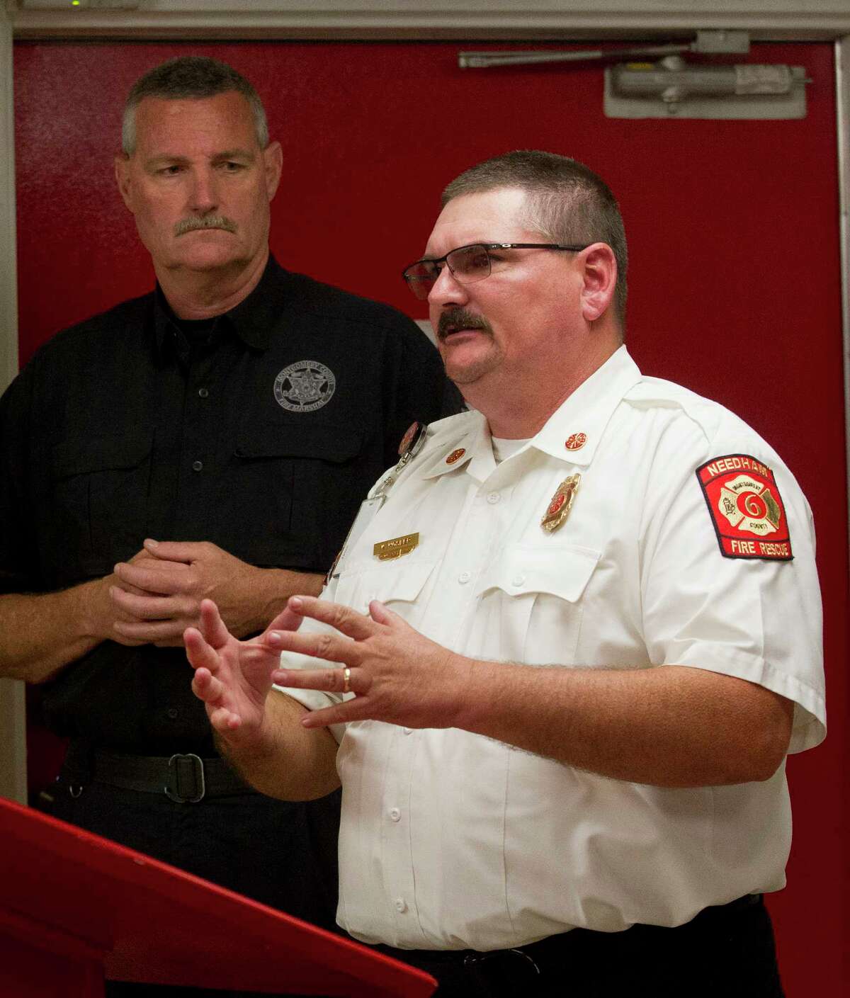 Montgomery County Fire Marshal Jimmy Williams speaks alongside Needham Fire Department Chief Kevin Hosler during a press conference at the Needham Fire Station, Thursday. Williams announced a new safety initiative to install smoke detectors in home for Tamina community, east of The Woodlands, at an event later to be determined. The initiative stems from a two-story house fire on May 12 in Tamina that killed three children and injured five others.