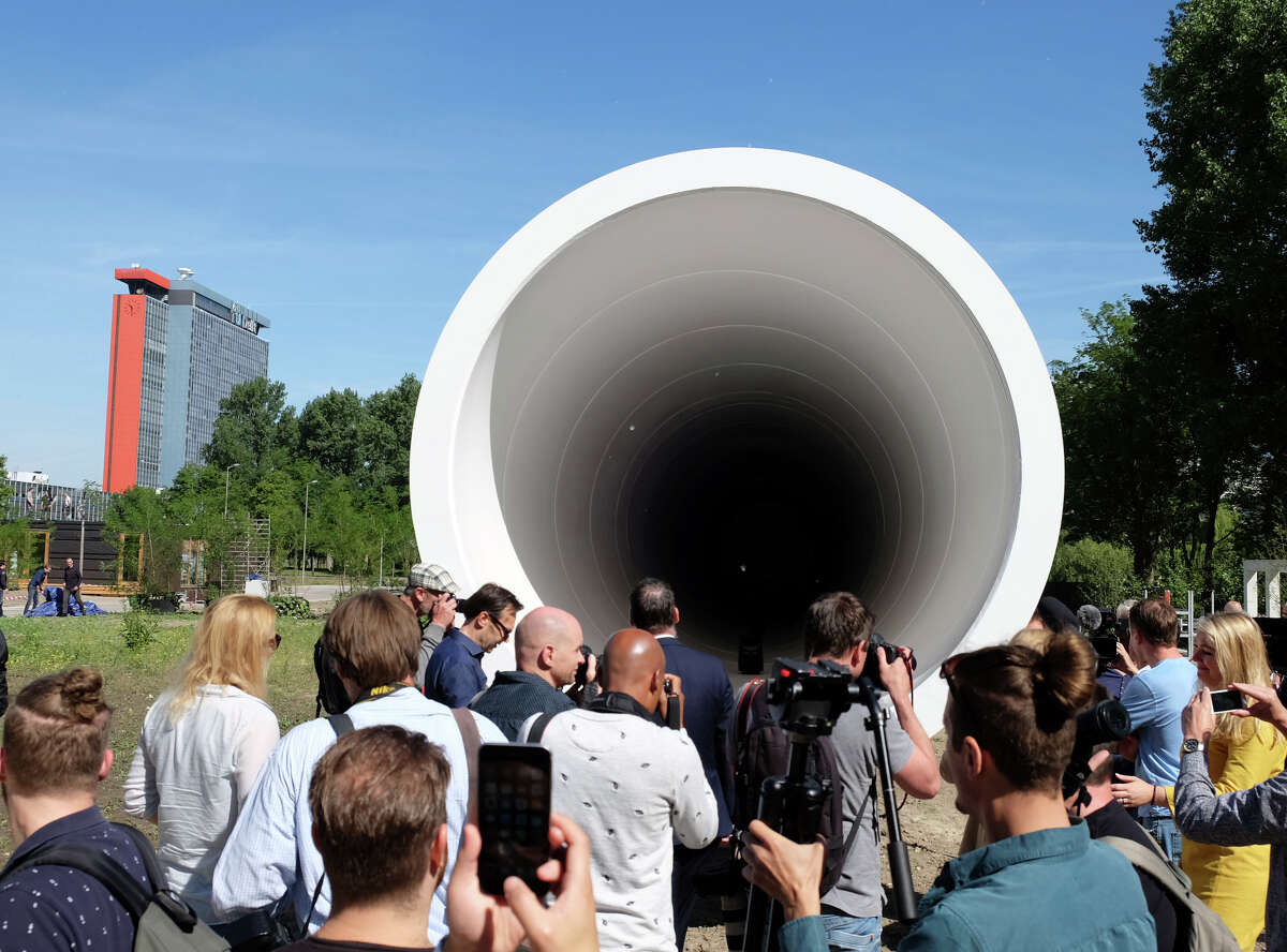 A crowd gathers at the Hyperloop test facility unveiled Thursday by a tech startup and a construction company at Delft Technical University in the Netherlands. The tube, 100 feet long and 10.5 feet in diameter, will be used for low-speed testing in a vacuum.