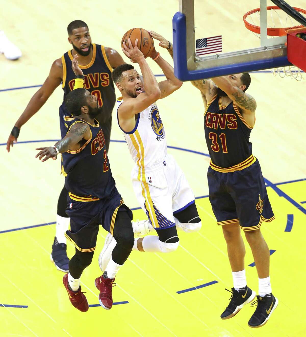 Golden State Warriors' Stephen Curry drives between Cleveland Cavaliers' Kyrie Irving and Deron Williams in 1st quarter during Game 1 of the NBA Finals at Oracle Arena in Oakland, Calif., on Thursday, June 1, 2017.