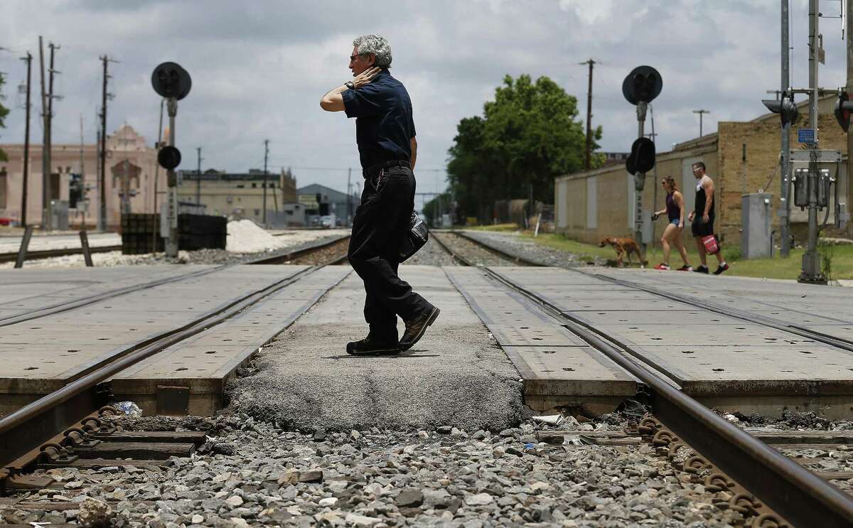 People walk past train tracks on Commerce near Sunset Station on Thursday, June 1, 2017. County Judge Nelson Wolff is thinking about a passenger rail line going from The Rim to Martin St. at Insterstate 35, using existing freight line tracks owned by Union Pacific. (Kin Man Hui/San Antonio Express-News)