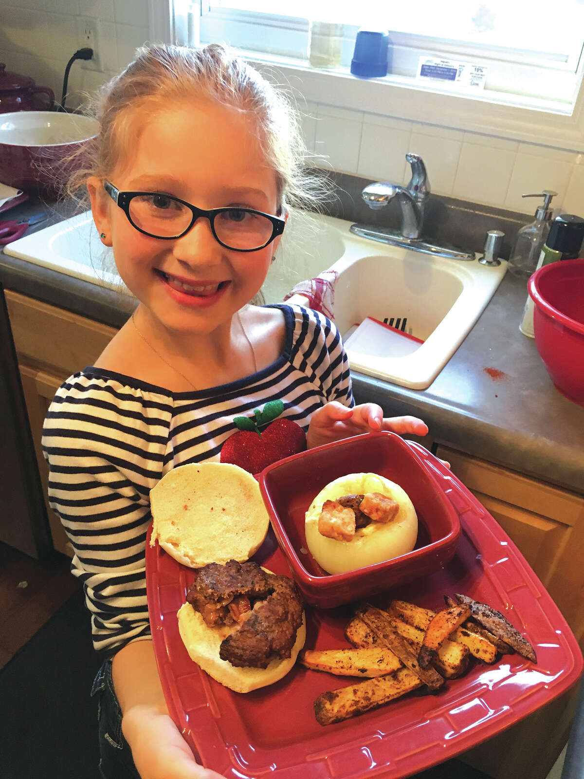 Ella Sedabres in her kitchen with some of her creations. She willl appear on the Food Network's Kids BBQ Championship Monday night.