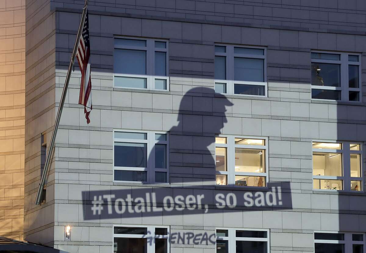 A Greenpeace banner showing U.S. President Donald Trump and the slogan '#TotalLoser, so sad!' is projected onto the facade of the U.S. Embassy in Berlin, Germany, Friday, June 2, 2017. Trump declared Thursday he was pulling the U.S. from the landmark Paris climate agreement, striking a major blow to worldwide efforts to combat global warming and distancing the country from its closest allies abroad. (AP Photo/Michael Sohn)