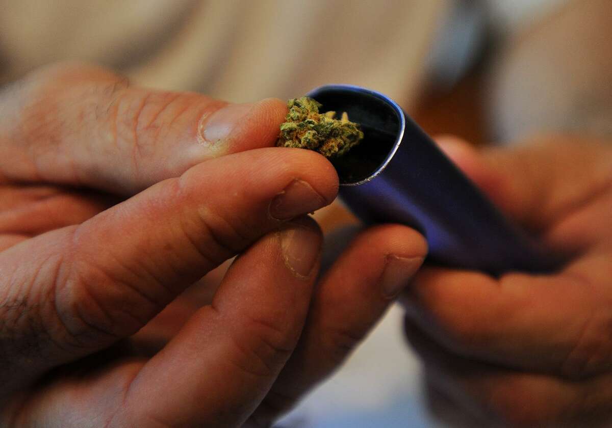 Medical marijuana patient William McDonald loads a cannibis bud into a vaporizer at his home in Monroe, Conn. on Sunday, August 9, 2015. McDonald uses cannibis in a variety of forms to treat his thyroid cancer, and symptoms from cancer treatment, like swelling in his legs. McDonald, who considers the drug a miracle cure for him, said he has lost 200 pounds in the last year and a half.