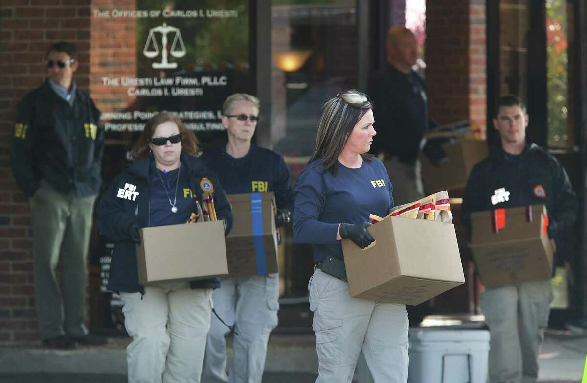 FBI agents carry boxes of evidence to a government truck after the FBI raided the office State Senator Carlos Uresti in San Antonio, Tx, on Thursday, Feb. 16, 2017.
