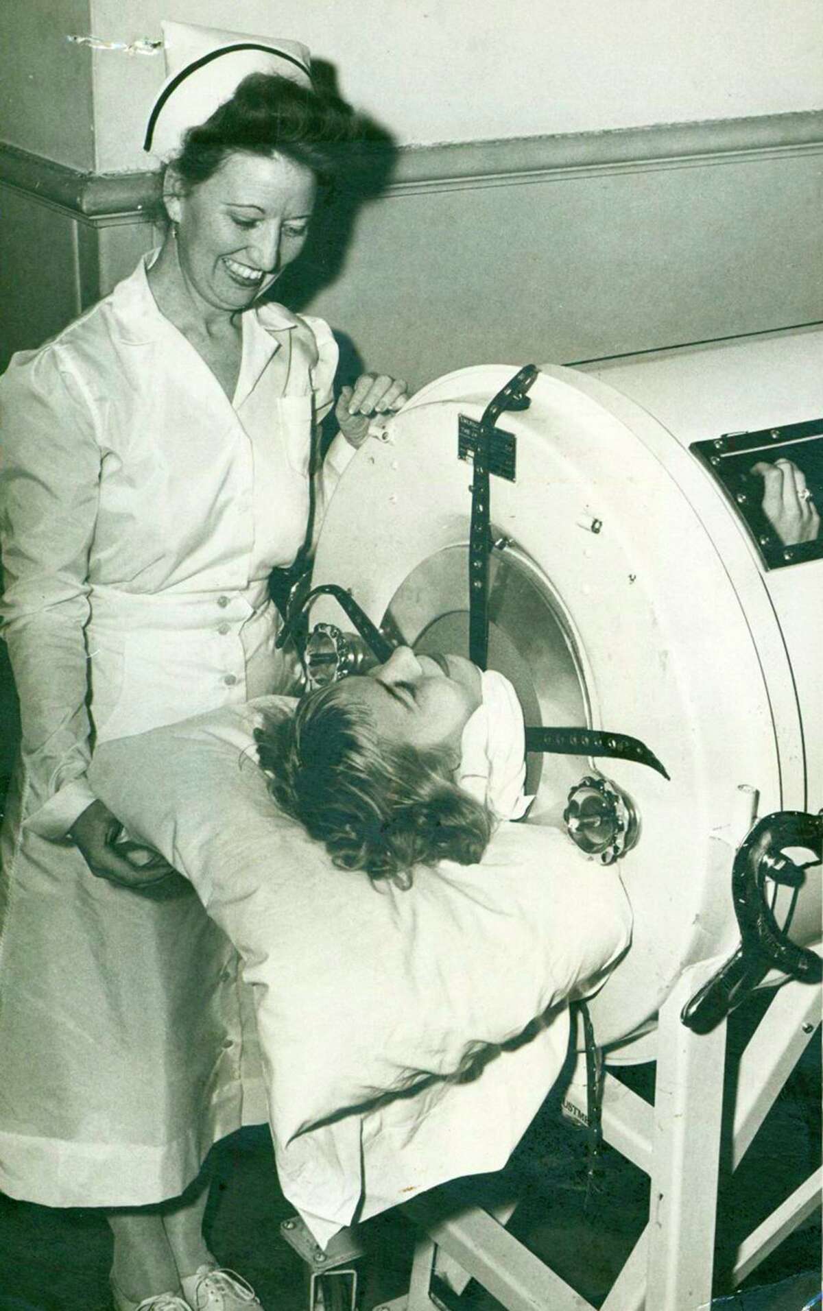 Della Barron, 17-year-old polio patient, spent nearly two weeks in one of the Robert B. Green Hospital's iron lungs in 1948. At her side is Supervisor Josephine Ricks. The iron lung helped victims of the potentially deadly virus breathe.