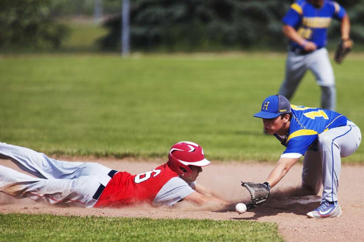 Beaverton's Cameron Schneider slides back to second base before being tagged by a Harrison infielder in the Division 3 quarterfinal game at Meridian on Saturday.