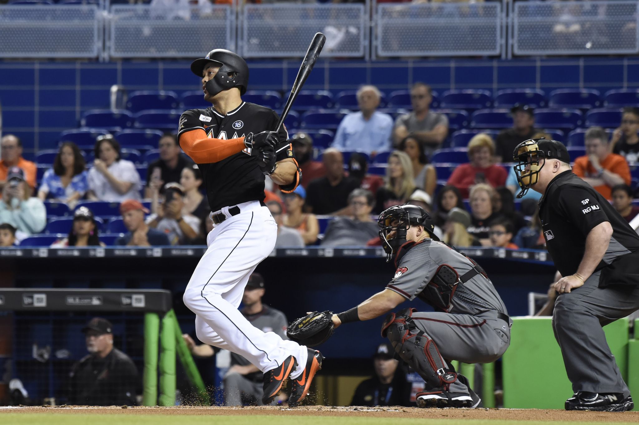 Miami Marlins' Miguel Rojas, wearing a mask, and Derek Dietrich