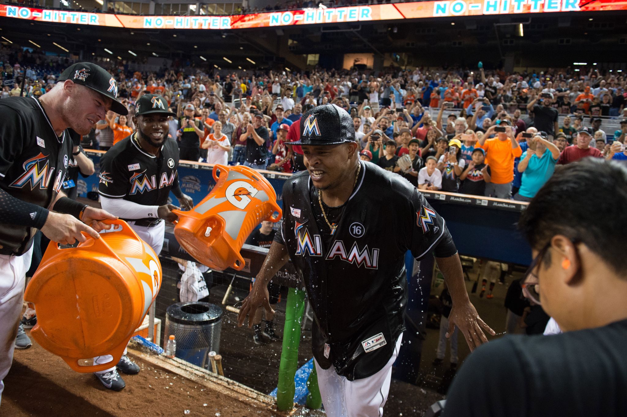 Miami Marlins' Miguel Rojas, wearing a mask, and Derek Dietrich