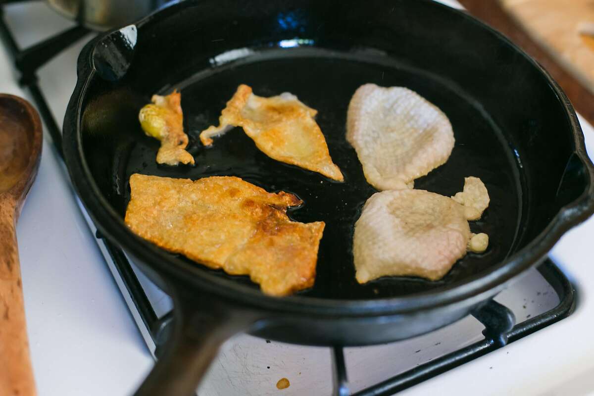 Chicken skin cooks in a castiron skillet at Kristen Rasmussen's home in Oakland.