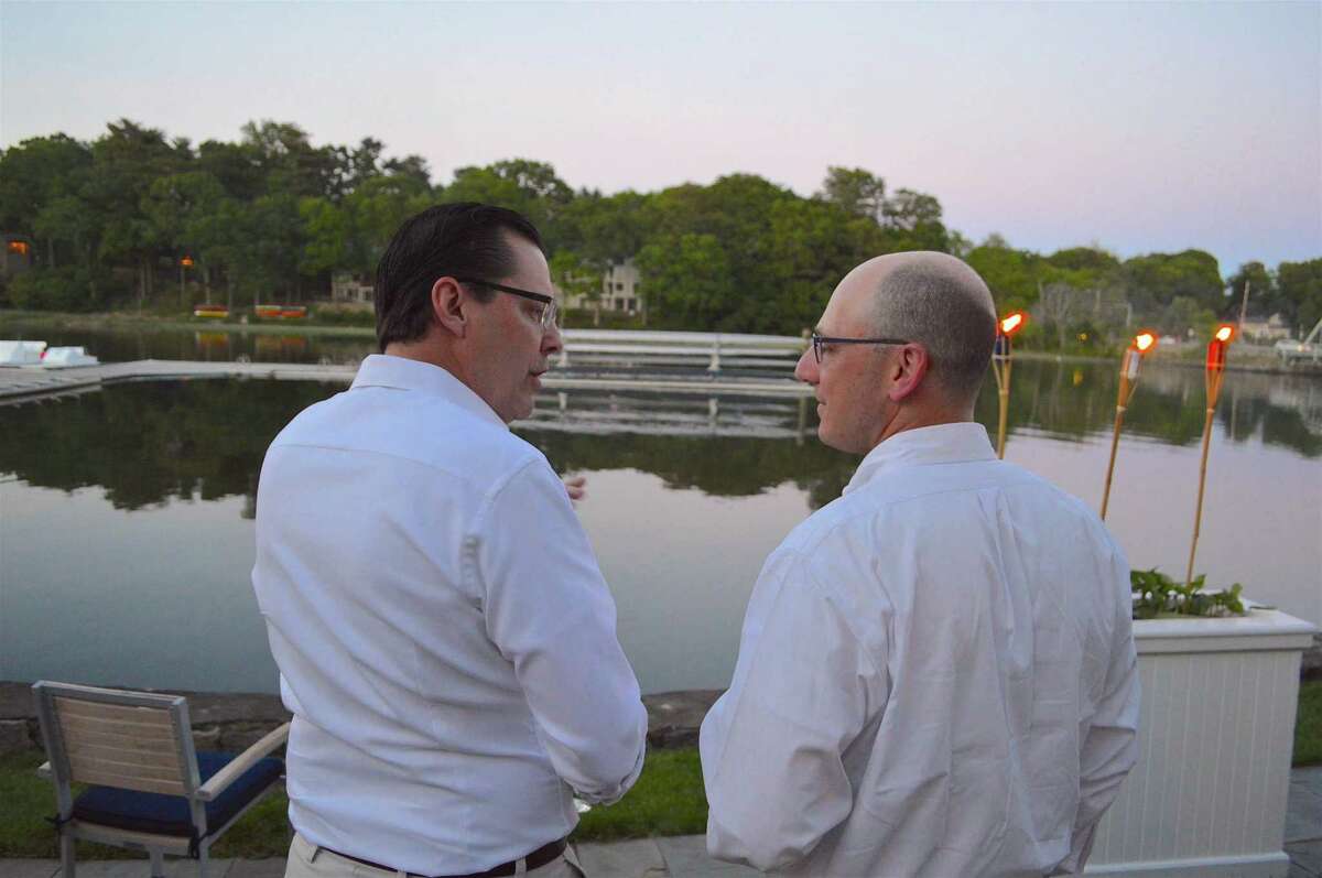 Bob Sprouls, left, and Jim Haskel, of Westport, chat by the water at the "Night on the River" Project Return fundraiser at the Saugatuck Rowing Club, Saturday, June 3, 2017, in Westport, Conn.