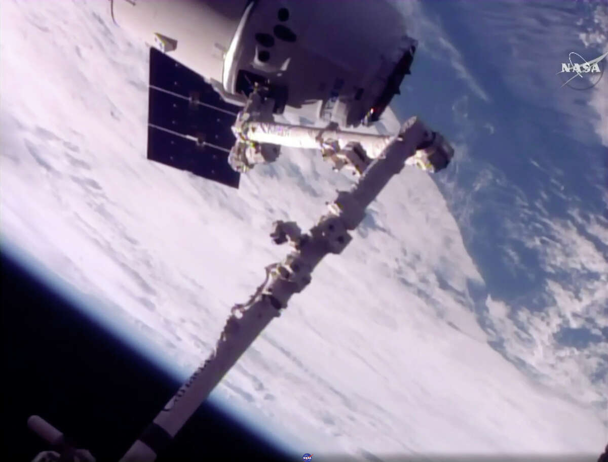 In this frame from NASA TV, a SpaceX Dragon arrives at the International Space Station on Monday, June 5, 2017, making an unprecedented second trip to the orbiting outpost. The Dragon supply ship, recycled following a 2014 flight, was launched from Florida on Saturday. (NASA TV via AP)