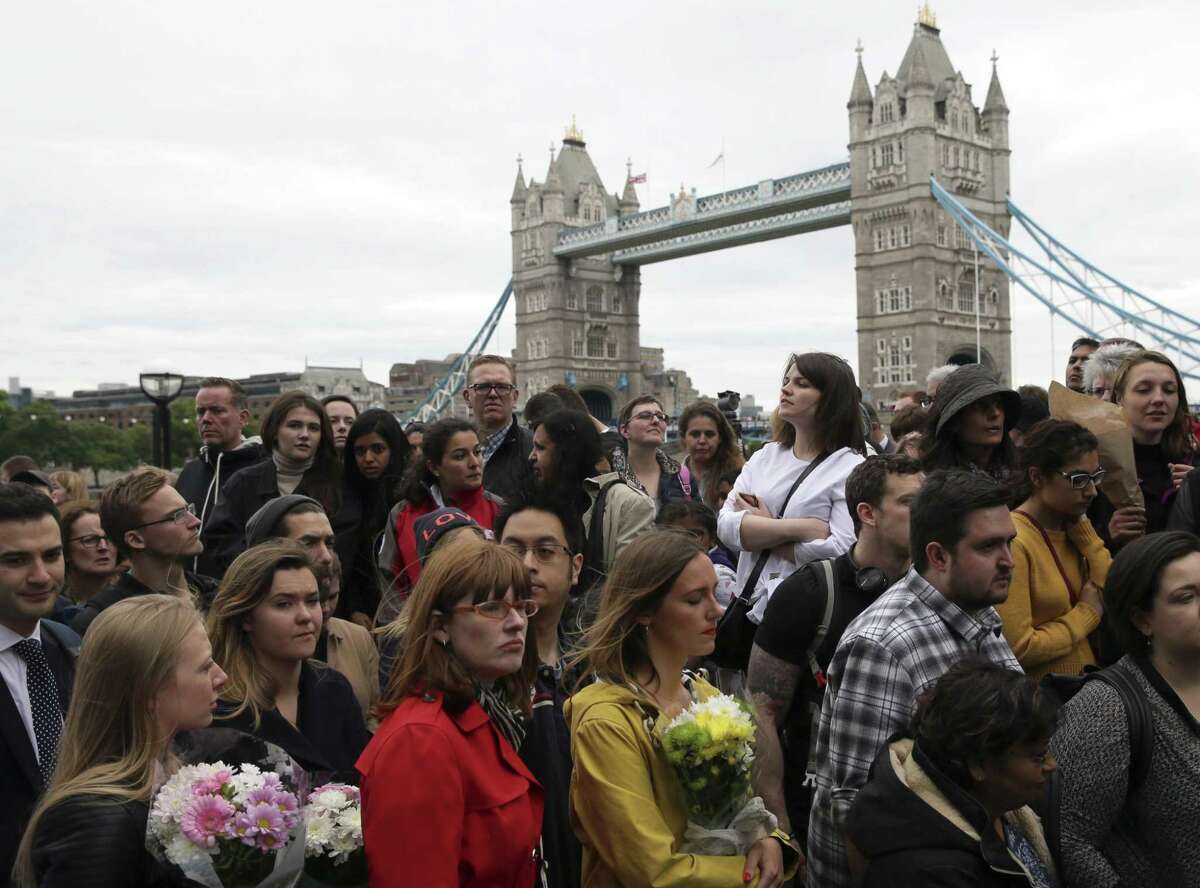 People queue to lay flowers after a vigil for victims of Saturday's attack in London Bridge, at Potter's Field Park in London, Monday, June 5, 2017. Police arrested several people and are widening their investigation after a series of attacks described as terrorism killed several people and injured more than 40 others in the heart of London on Saturday.