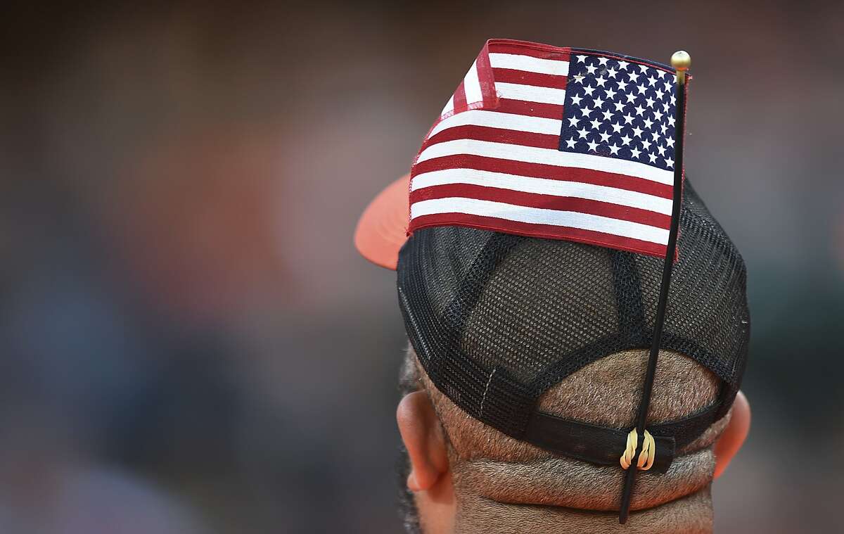 A vendor with an American flag in his hat sells beer during the Baltimore Orioles and Boston Red Sox baseball game, Saturday, June 3, 2017, in Baltimore. (AP Photo/Gail Burton)