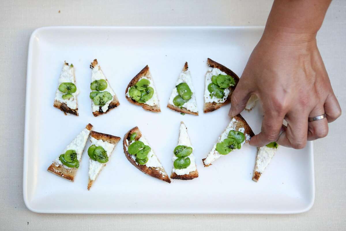 Emily Su prepares a fava bean crostini for guests at a private dinner party at Suzy Kellums Dominik's home on Friday, June 2, 2017 in San Francisco, Calif.