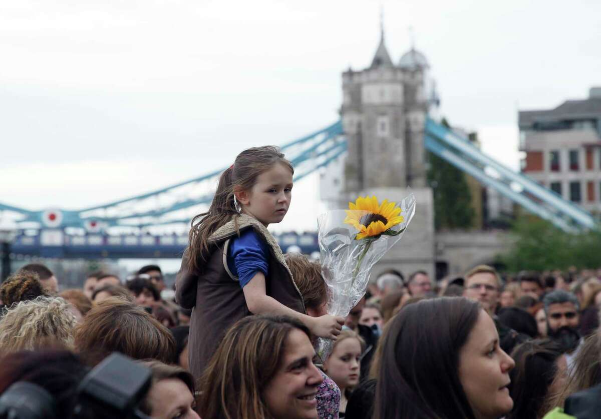 People attend a vigil at Potter's Field Park in London for victims of Saturday's attack. Rival politicians are trading blame over one another's security policies.﻿