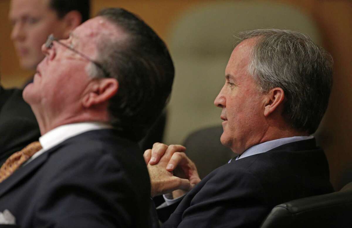 Texas Attorney General Ken Paxton (right) and his attorney Dan Cogdell sit at the defense table during a February pretrial hearing at Collin County Courthouse in McKinney.