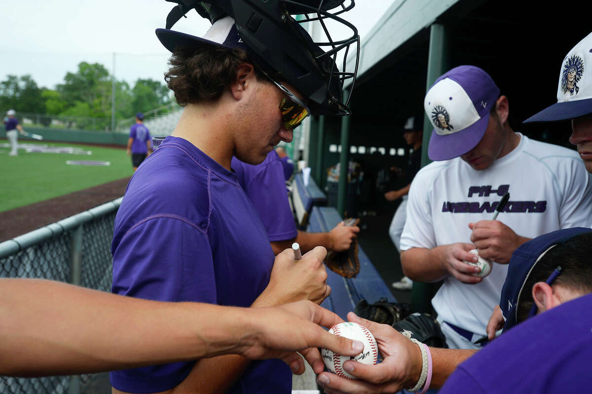 Port Neches-Groves catcher Braxton Boudoin, left, signs baseballs with his teammates during practice on Monday. The team will play in the state semi-finals on Thursday. Photo taken Monday 6/5/17 Ryan Pelham/The Enterprise