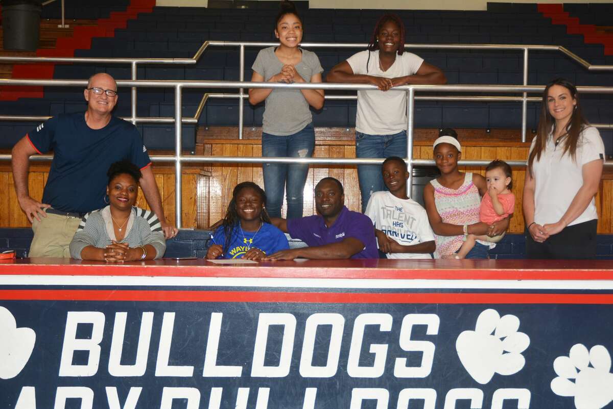 Plainview’s Jade Nails, seated third from left, signs a letter of intent to play basketball for the Wayland Baptist University Flying Queens. Looking on are front row, from left, Plainview Lady Bulldog coach Danny Wrenn, Jade’s mom Belinda Nails, her dad Damien Nails, her brother Brock Nails, her sister Brooke Nails holding 1-year-old Jaylee Ramirez, and Flying Queens coach Alesha Robertson-Ellis. Back row, from left, Jade’s cousin Jordan Minjarez and her sister Mahogany Nails.