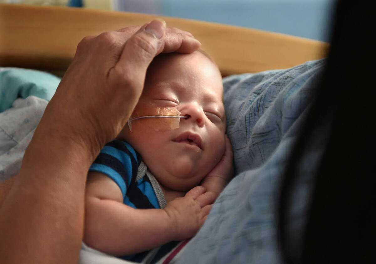 Volunteers cuddle babies to help them get well