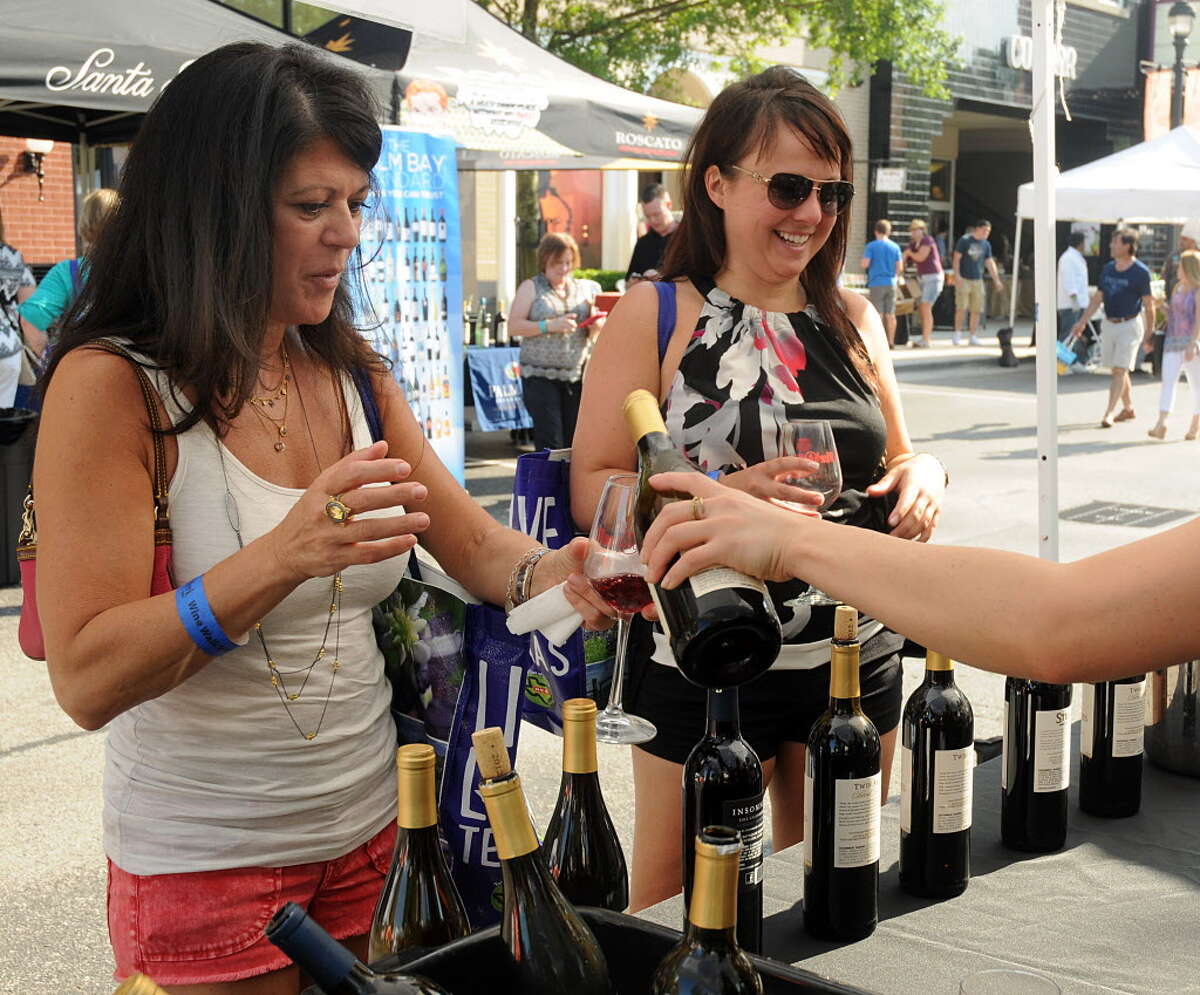 Christine Rubeis and Nancy Chafe, both of The Woodlands, sample wine at a booth during the H-E-B Wine Walk at Market Street. Attendees were able to sample numerous wines and food samples during the Wine Week event.