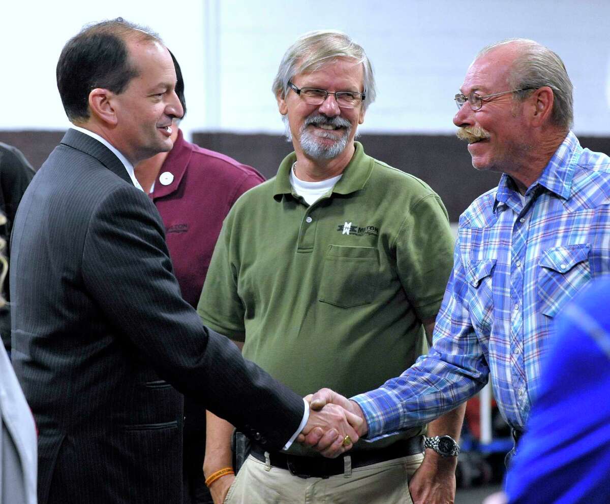 U.S. Secretary of Labor Alexander Acosta, left, shakes hands with Rodney Tschirhart, right, who has 41-years of service with Milton after meeting Kenneth Jaynes, center, who has 39 years of service with company, Thursday, June 1, 2017, in Detroit. Acosta discussed how to better prepare American workers for careers in advanced manufacturing. Milton Manufacturing is a woman-owned business that provides metal and fabric solutions for the defense, automotive, aerospace, heavy truck, rail, agriculture and energy industries. (Todd McInturf/Detroit News via AP)