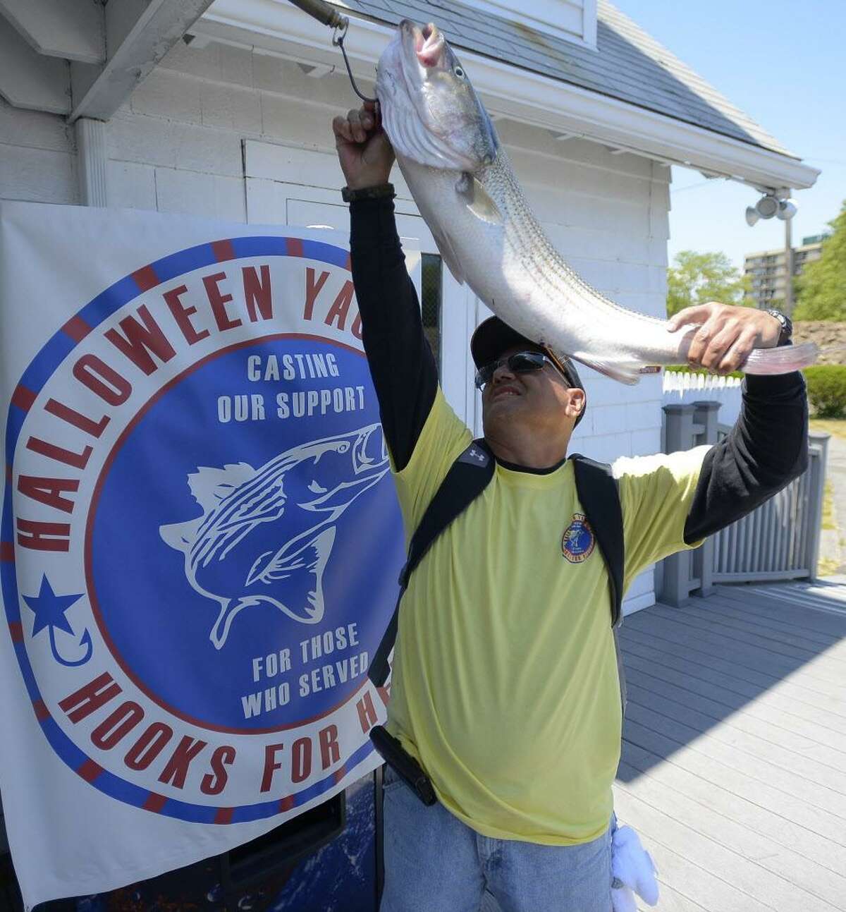 FILE — Newly retired, after 38 years of service, U.S. Army Staff Sergeant Steven Betancourt, who served in combat and was wounded in the Iraq war, weighs in a 14 lbs Striped Bass during the Hooks for Heroes Charity Fishing Tournament at the Halloween Yacht Club in Stamford, Conn. on Saturday, June 25, 2016.