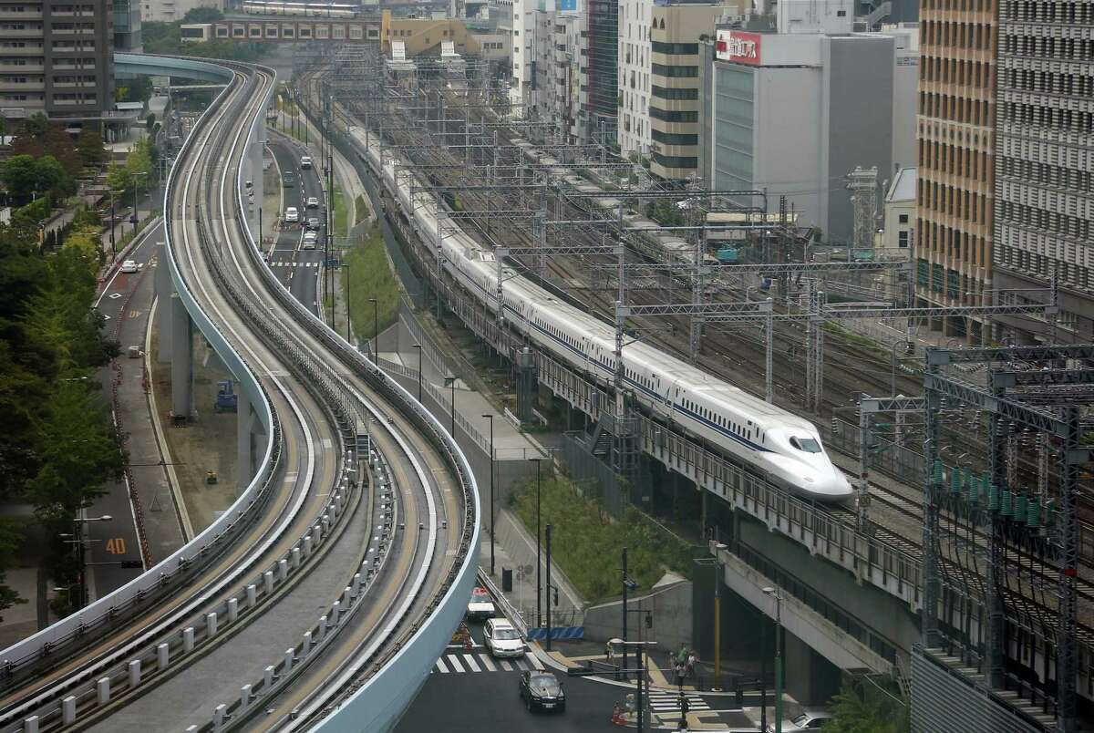 In this Sept. 24, 2014, file photo, a Shinkansen bullet train heads for Tokyo Station on the Tokaido Main Line in Tokyo. The Shinkansen bullet train began service in 1964 in time for the Olympics that year and become a symbol of Japan's technological prowess. (AP Photo/Shizuo Kambayashi, File)